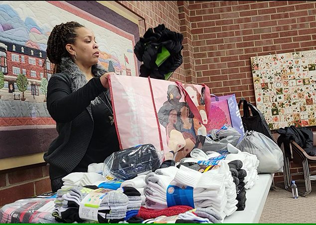 Katari Coleman, Plan4Success education director, sorts socks to be donated to area shelters. (Eric Crump/H-F Chronicle)