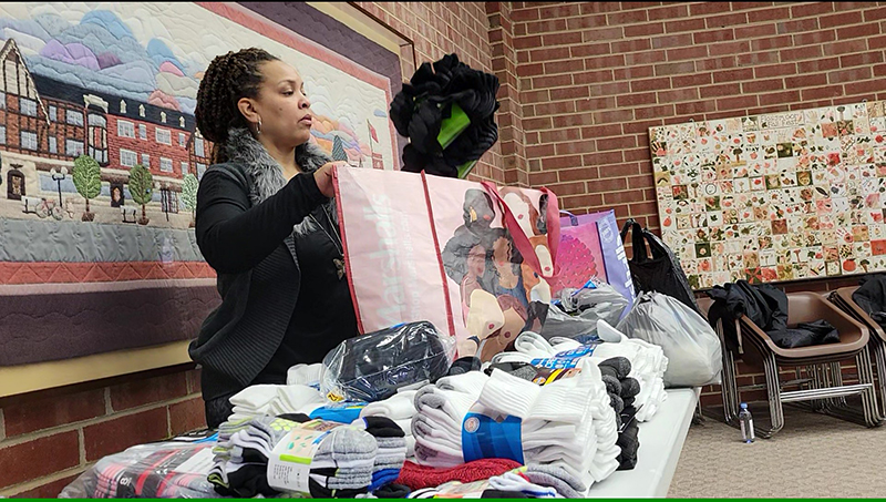 Katari Coleman, Plan4Success education director, sorts socks to be donated to area shelters. (Eric Crump/H-F Chronicle)