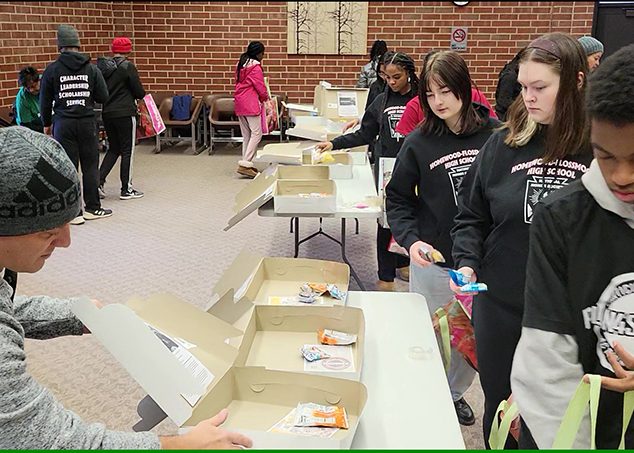 Volunteers begin filling care package boxes with treats for first responders. (Eric Crump/H-F Chronicle)