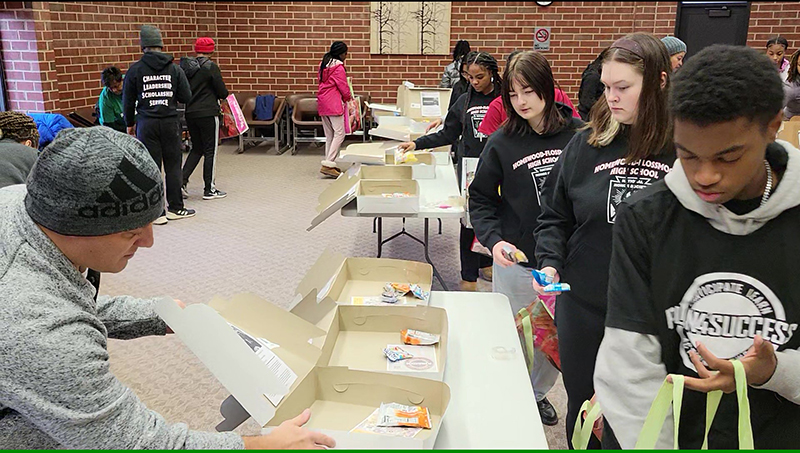 Volunteers begin filling care package boxes with treats for first responders. (Eric Crump/H-F Chronicle)