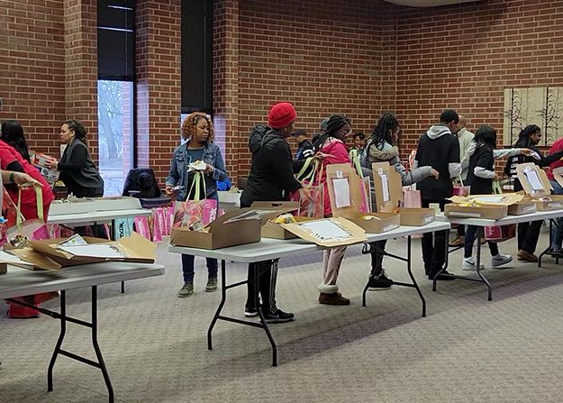 Volunteers form an assembly line to create care packages for first responders during the Plan4Success MLK Day of Service project in 2023. (Eric Crump/H-F Chronicle)