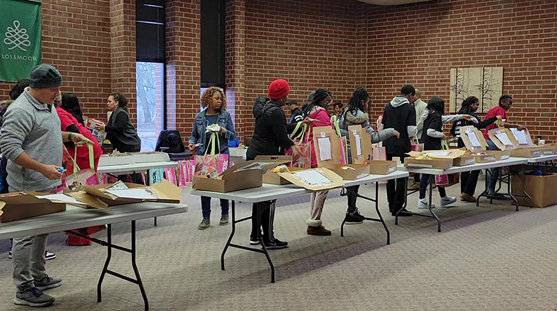 Volunteers form an assembly line to create care packages for first responders during the Plan4Success MLK Day of Service project in 2023. (Eric Crump/H-F Chronicle)