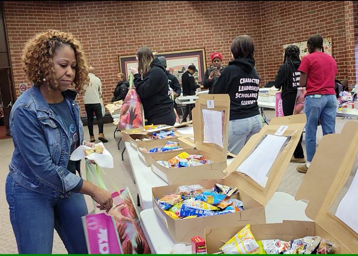 Flossmoor Trustee Joni Bradley-Scott helps fill care packages with treats for area first responders. (Eric Crump/H-F Chronicle)