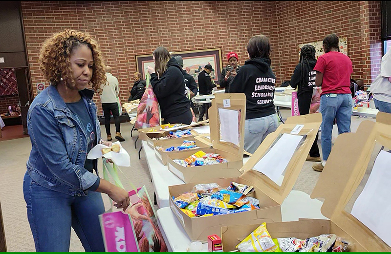 Flossmoor Trustee Joni Bradley-Scott helps fill care packages with treats for area first responders. (Eric Crump/H-F Chronicle)