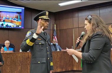 Jerel Jones, left, takes the oath of office as Flossmoor's new police chief at the Board of Trustees meeting Monday, March 27. (Eric Crump/H-F Chronicle)