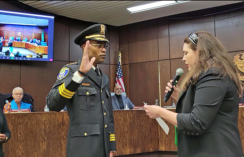 Jerel Jones, left, takes the oath of office as Flossmoor's new police chief at the Board of Trustees meeting Monday, March 27. (Eric Crump/H-F Chronicle)