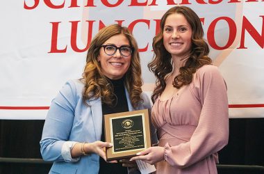 Makenzie Russell, right, a senior at Homewood-Flossmoor High School, receives the Keith Magnuson Blackhawk Alumni High School Hockey Scholarship Award from Michelle Morgan, the first female recipient, who received the honor in 2001. (Provided photo)
