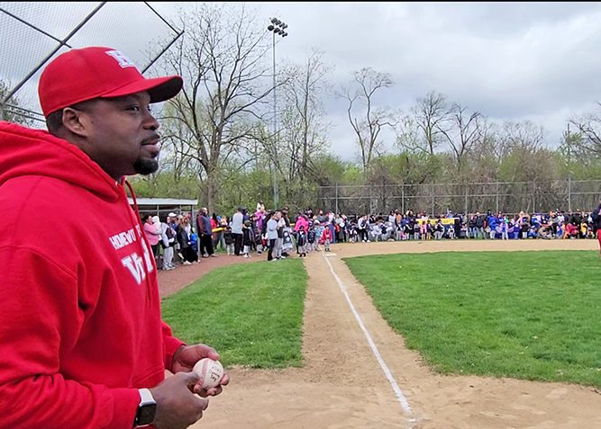 H-F High School Principal Clinton Alexander prepares to throw out the first pitch after serving as parade grand marshal. (Eric Crump/H-F Chronicle)
