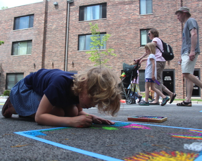 A youngster concentrates on a work of chalk art during the 2015 Art & Garden Fair in Homewood. The village is bringing back chalking in a big way this year with a new event focused on creating chalk art. (Chronicle file photo)
