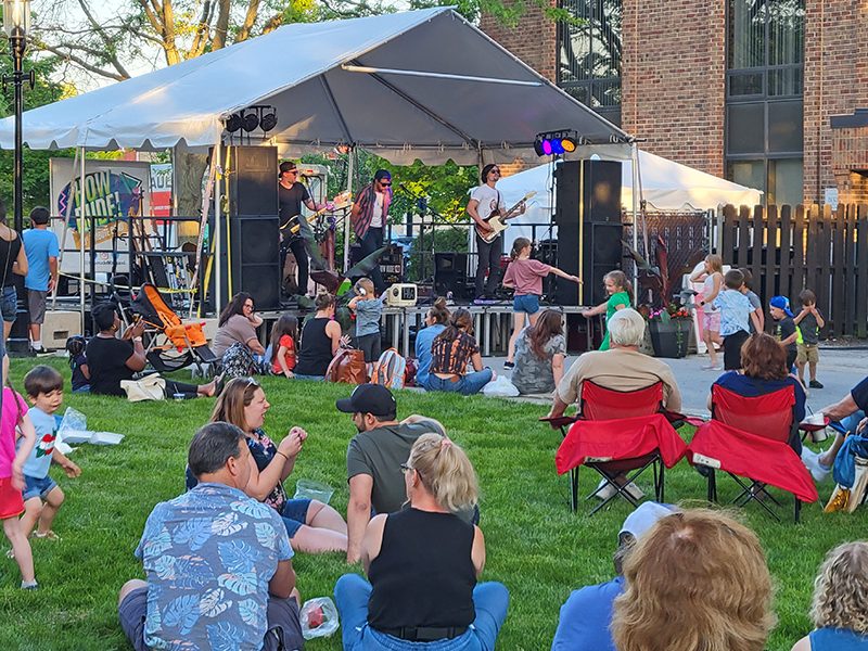 People relax on the lawn of the Gottschalk House to listen to a band at the 2022 Artisan Street Fair in Homewood. (Chronicle file photo)