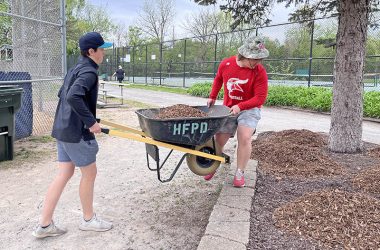 H-F High School baseball players Cormac Saunders, left, and Cameron Williams move mulch at Flossmoor Park during 2023 Park Pride day. (Nuha Abdessalam/H-F Chronicle)