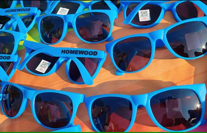 Homewood staff give away sunglasses at the village's table. (Eric Crump/H-F Chronicle)