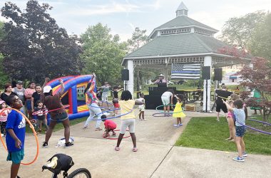 Community members play a hoola hoops game refereed by the DJ at National Night Out in Irwin Park. (Nick Ulanowski/H-F Chronicle)