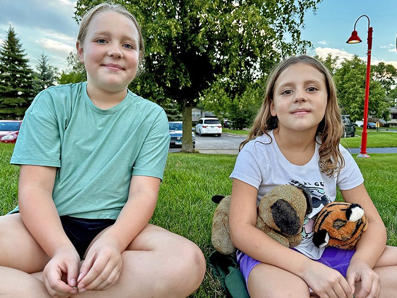 Audi Bjorklund, 9, (left) and her sister Alexa, 7, watch their uncle Mak Beattie play for the Diamond Dogs. The girls were able to try out their kicking skills after the official game was over. (Karen Torme Olson/H-F Chronicle)