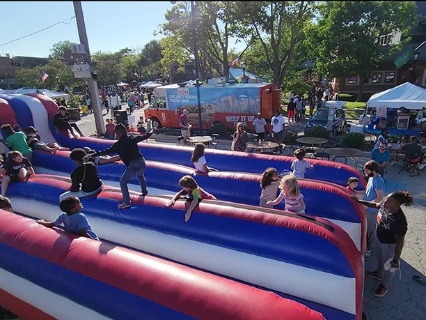 Kids frolic on one of several inflatable play areas during Flossmoor Fest. (Eric Crump/H-F Chronicle)