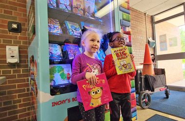 Ava Deguilio, left, and Carter Casey show the books they obtained from the new vending machine in Willow School. (Eric Crump photos/H-F Chronicle)