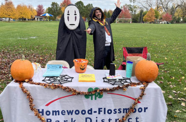 Steve Rab, right, and Bob Birgel at the Homewood-Flossmoor Park District table are ready for trick or treaters at Millennium Park on Oct. 28. (Nuha Abdessalam/H-F Chronicle)