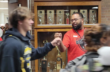 Edrick Salomon, a member of the H-F Dad Squad, greets students with fist bumps during one passing period on Oct. 30.