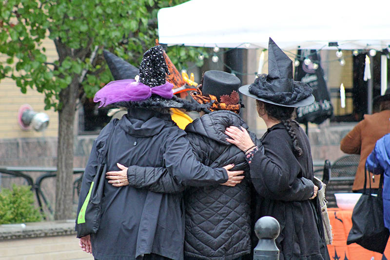 Community members sporting spooky witches' hats gather at Martin Square Homewood for Witches' Night Out. (Nuha Abdessalam/H-F Chronicle)