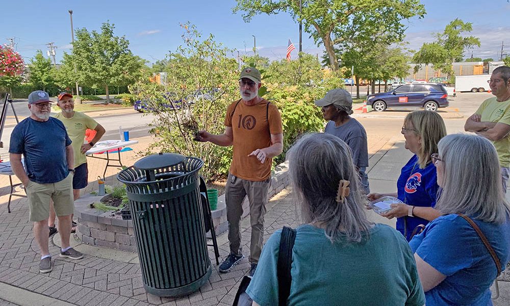 Tristan Shaw, center, uses a container-grown tree to explain how root systems develop during a Green Thumb Saturdays presentation on July 12. (Nuha Abdessalam/H-F Chronicle)