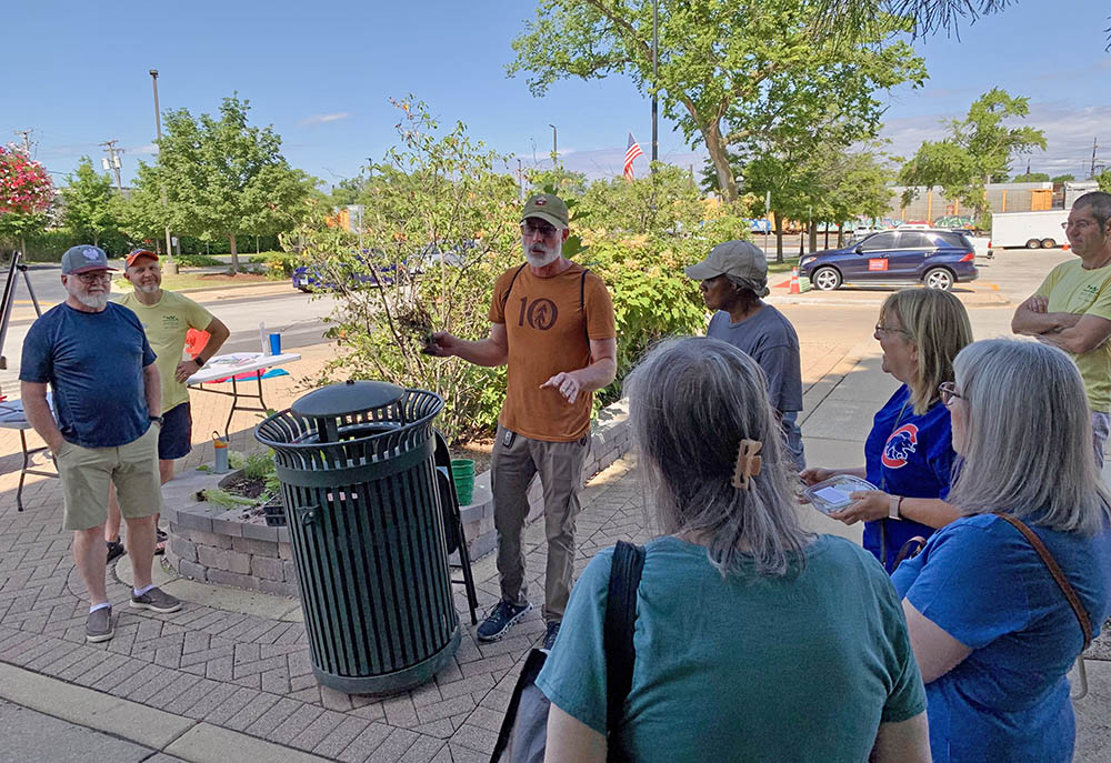 Tristan Shaw, center, uses a container-grown tree to explain how root systems develop during a Green Thumb Saturdays presentation on July 12. (Nuha Abdessalam/H-F Chronicle)