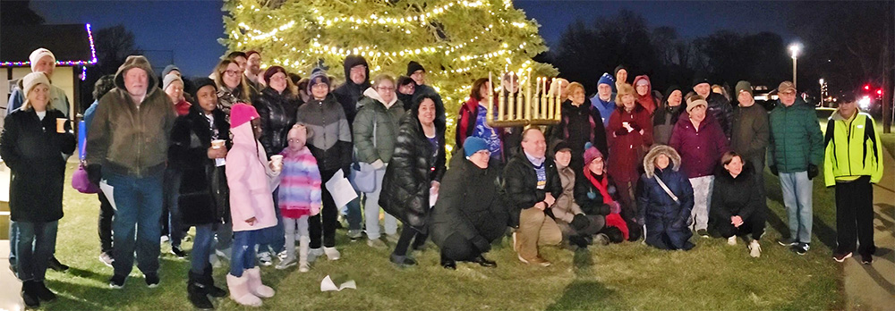 The community members gathered for the sixth night of Hannukah in Flossmoor pose for a group photo following the ceremony.