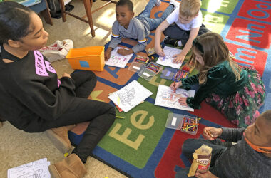 Journey Franklin watches kindergarteners work on coloring sheets. The eighth grader started her visit to Willow School reading them holiday stories. (Marilyn Thomas photos/H-F Chronicle)