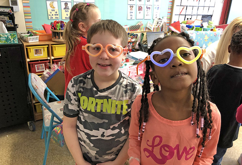Hiram Cheffer, left, and Elianna Kline, first graders at Willow School, show off their 'love' glasses as the class celebrated Valentine's Day Wednesday. (Marilyn Thomas/H-F Chronicle)