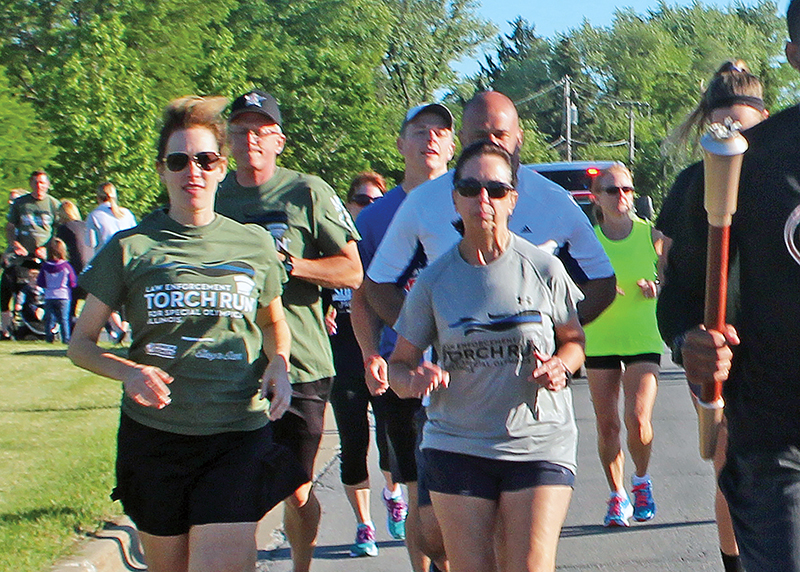 Homewood Police Chief Denise McGrath, center, runs in the Torch Run to raise funds for Special Olympics. She is a long-time runner who finally got to run in Flossmoor's Hidden Gem Half Marathon this year. (Chronicle file photo)