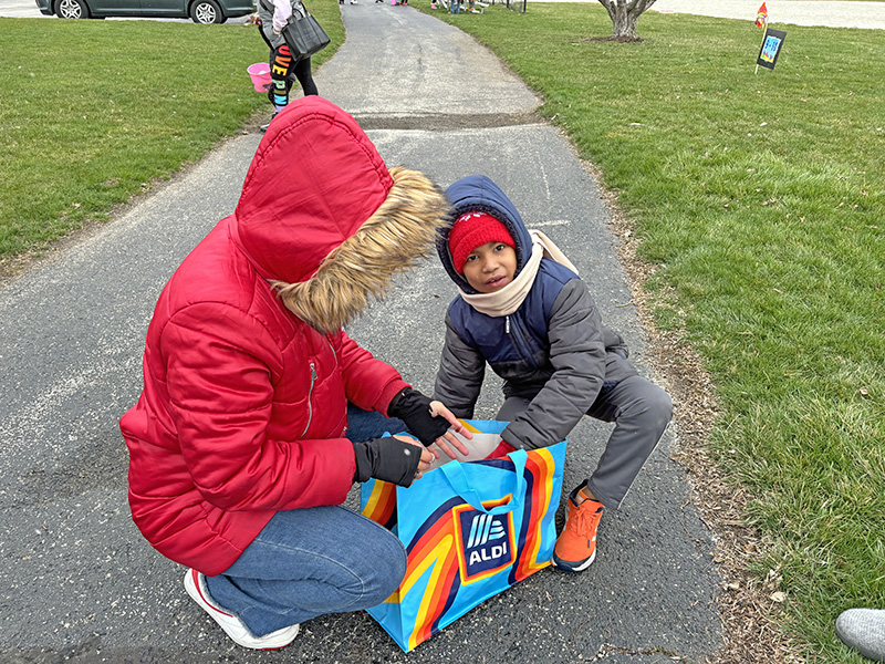 Frederick Brunson, 9, gets an assist from big sister Adriana Brunson as they go through his egg collection looking for the golden ticket that could win him a prize. (Marilyn Thomas/H-F Chronicle)