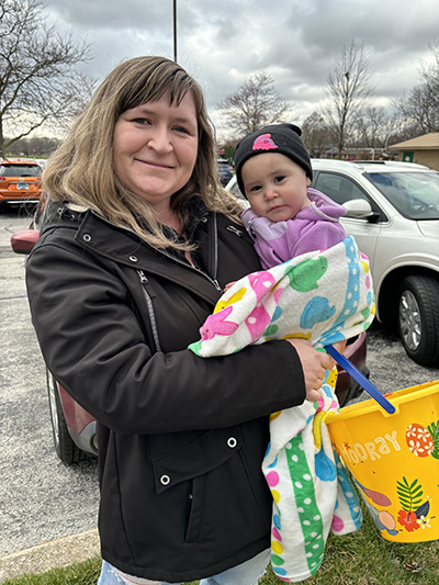 Alisha Martinez tries to keep one-year-old Aria Martinez warm. (Marilyn Thomas/H-F Chronicle)