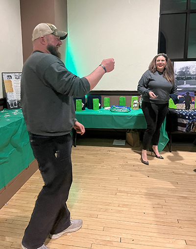 FVM steering committee member Josh Grenard holds up a winning raffle ticket and reads it as Gina LoGalbo, a Flossmoor Village Clark and FVM steering committee member, looks on. (Nick Ulanowski/H-F Chronicle)