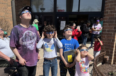 Adam Kammin, left, and his nephews and niece looking up at the solar eclipse April 8 at Homewood Public Library. (Nick Ulanowski/H-F Chronicle)