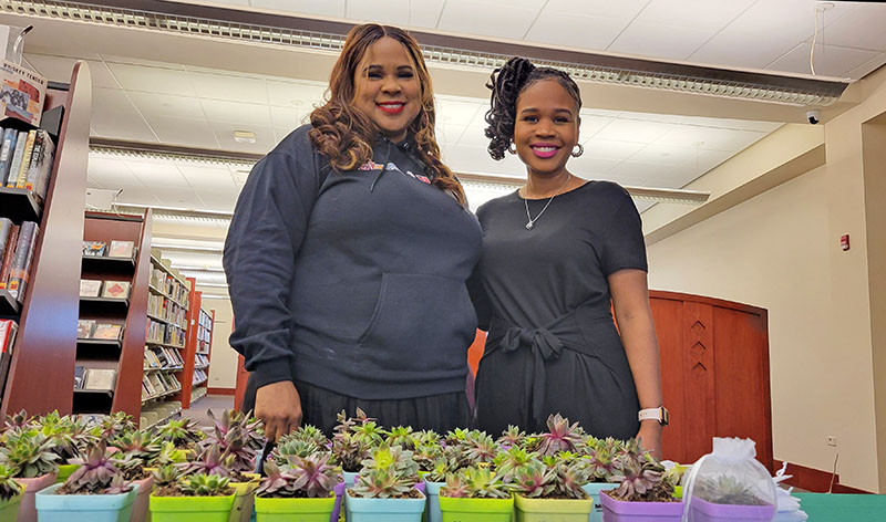 Kellie Lucas, owner of Birch + Bloom, with her assistant, Kia Thomas, offer free sample plants during the new Flossmoor resident reception April 13. (Eric Crump/H-F Chronicle)