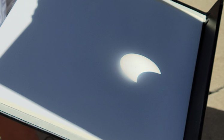 The shadow of the moon is getting more prominent on a reflection of the eclipse. (Eric Crump/H-F Chronicle)