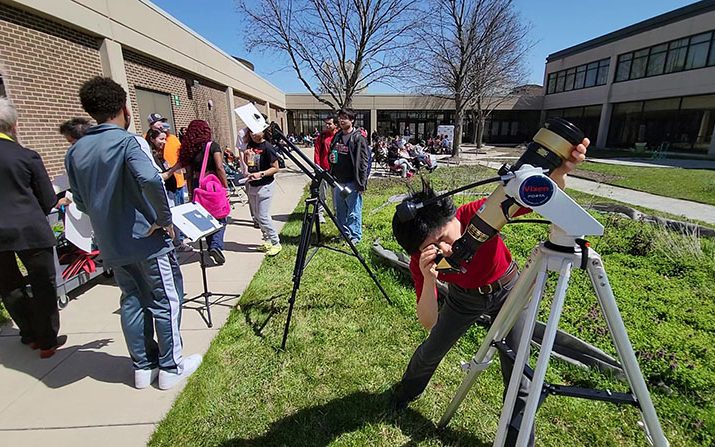 Haiming Wang, PSC professor and coordinator of physics and astronomy, adjusts a solar telescope during the eclipse viewing event April 8. (Eric Crump/H-F Chronicle)