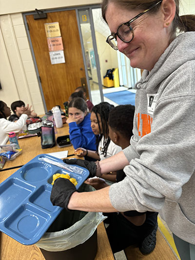 Christine Scully is one of several parents who volunteered to come in during the lunch period and collect food waste for a composting project at Churchill School. (Marilyn Thomas/H-F Chronicle)