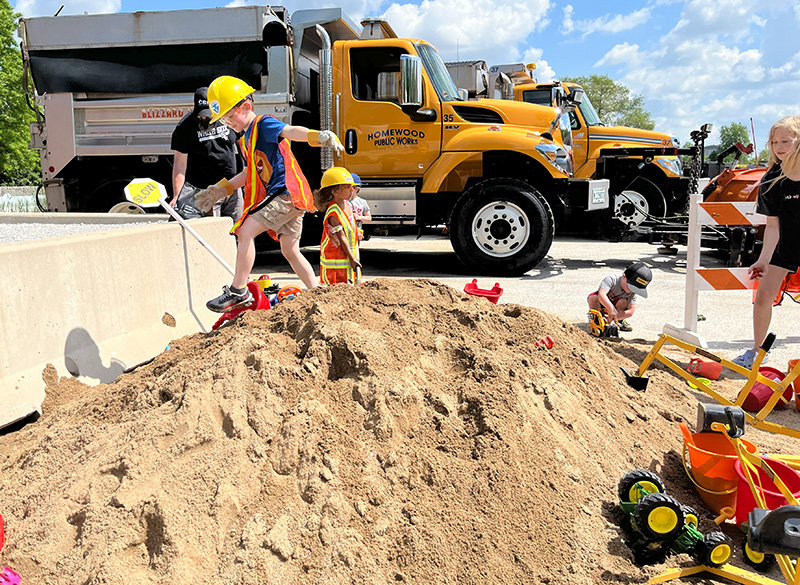 Ethan Bauer and Hope Peele play on a sand hill at the Homewood Public Works Department open house on May 18, 2024. (Nuha Abdessalam/H-F Chronicle) 