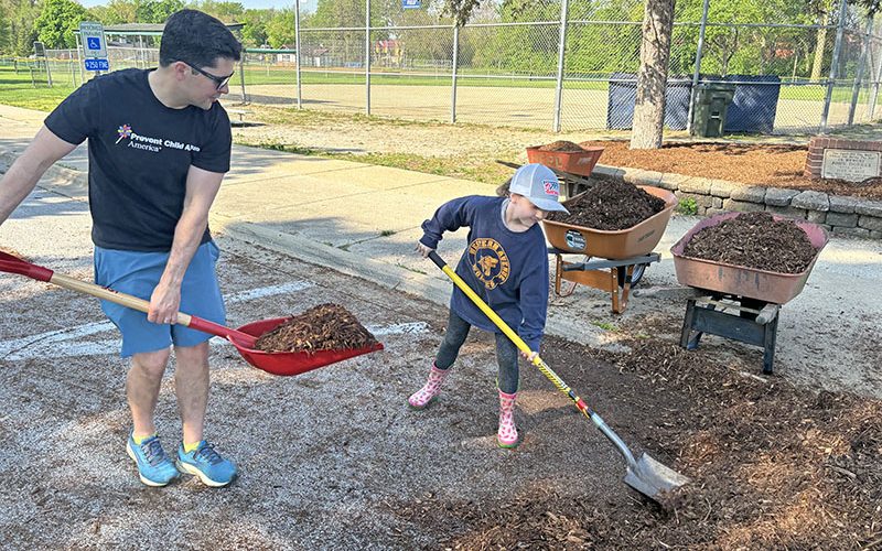 Bart Klika and his daughter, Piper, 8, were on the crew moving mulch at Flossmoor Park. (Marilyn Thomas/H-F Chronicle)