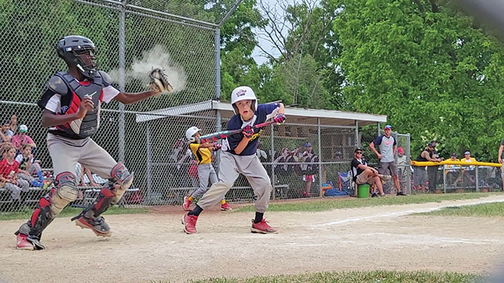 The batter shows bunt as the catcher prepares to throw to second in an attempt to thwart a steal during the youth baseball exhibition game at Flossmoor's centennial celebration on June 20. (Eric Crump/H-F Chronicle)