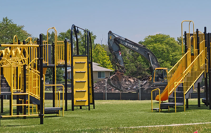 Excavating equipment removes the tennis court on Lawrence Crescent in preparation for digging a storm water detention basin with Heather Hill School playground in the foreground. (Eric Crump/H-F Chronicle)