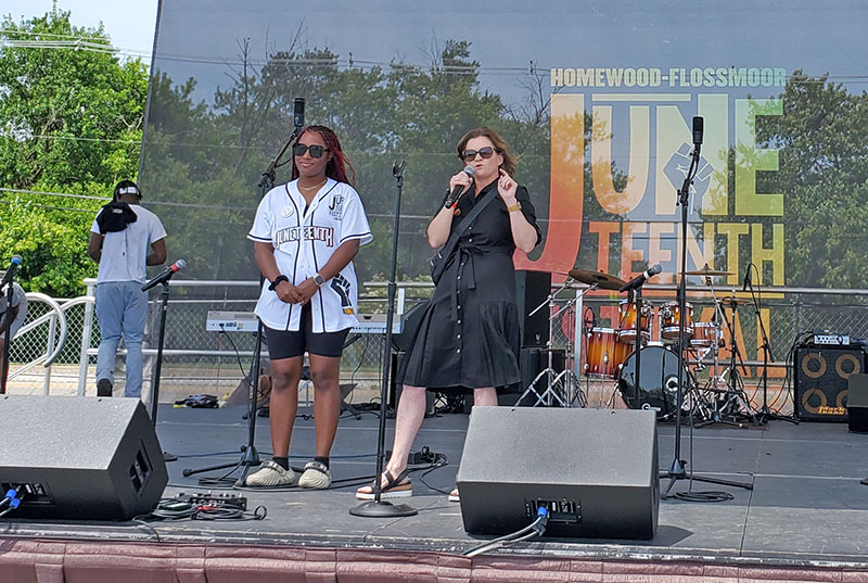 You Matter 2 founder Destiny Watson, left, listens to Flossmoor Mayor Michelle Nelson's opening remarks to kick off the 2024 HF Juneteenth Festival on Saturday, June 15. (Chris Weber/H-F Chronicle)