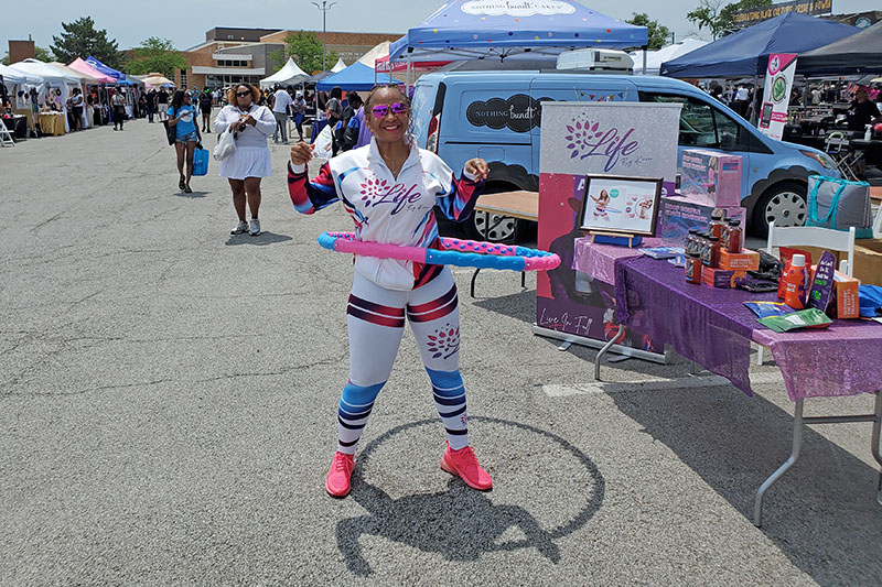 Kara Scott Dentley shows off examples of her clothing products and her hula hoop skills at the HF Juneteenth Festival. (Chris Weber/H-F Chronicle)