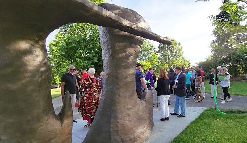 Flossmoor officials and residents of the Ballantrae neighborhood mingle in the shadow of "Paradise" by the late Hubert Phipps after a ribbon cutting ceremony on May 31 to mark the installation of the sculpture in Ballantrae Park, 1404 Lanark Ave. (Eric Crump/H-F Chronicle)