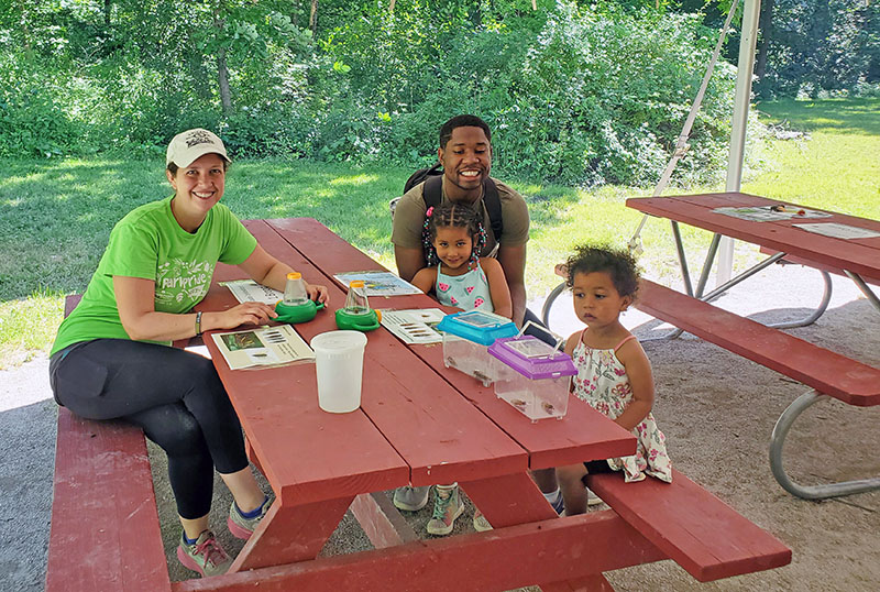 Caitlin McCaffery (left), Lavon Robinson (back), Amara Robinson (middle) and Noa Robinson (front) take a close look at the cicadas collected by Iron Oaks staff. (Chris Weber/H-F Chronicle)
