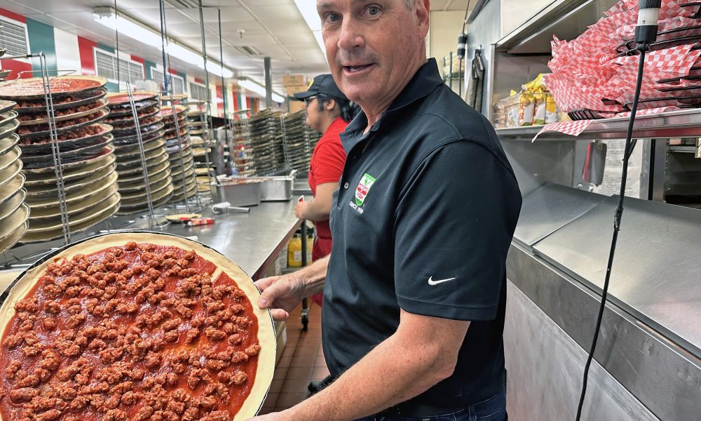 Joe Aurelio displays a pizza in progress in the Homewood store's kitchen. All of Aurelio's pizzas, pastas, and other offerings are produced using fresh ingredients and authentic Calabrian recipes. See the story on pages 16 and 17. (Karen Torme Olson/H-F Chronicle)