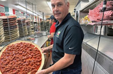 Joe Aurelio displays a pizza in progress in the Homewood store's kitchen. All of Aurelio's pizzas, pastas, and other offerings are produced using fresh ingredients and authentic Calabrian recipes. See the story on pages 16 and 17. (Karen Torme Olson/H-F Chronicle)