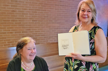 Sisters Cheryl (Buckingham) Van Naarden Boers left, and Julie (Buckingham) Albrecht show the hymnal their family donated to St. Andrew United Methodist Church. (Eric Crump/H-F Chronicle)