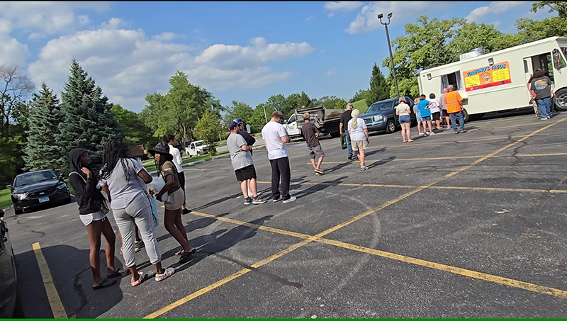 Southgate residents line up for a free taco from Juancho's food truck on Friday, July 19, courtesy of the Village of Homewood. (Eric Crump/H-F Chronicle)