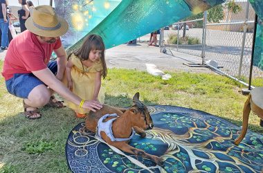 Patrick and his daughter Emma pet a goat at the Feast. (Chris Weber/H-F Chronicle)